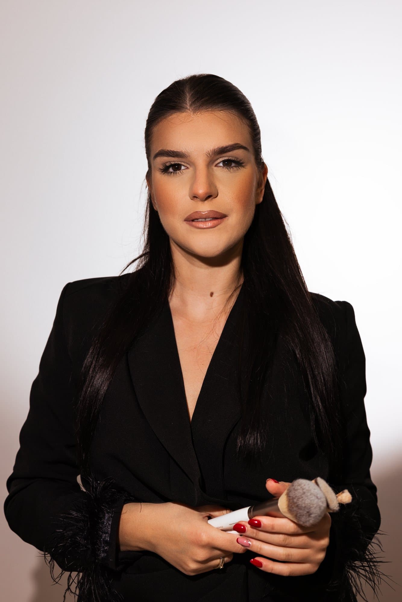 Melani Drmać, makeup artist, drži kistove za šminkanje